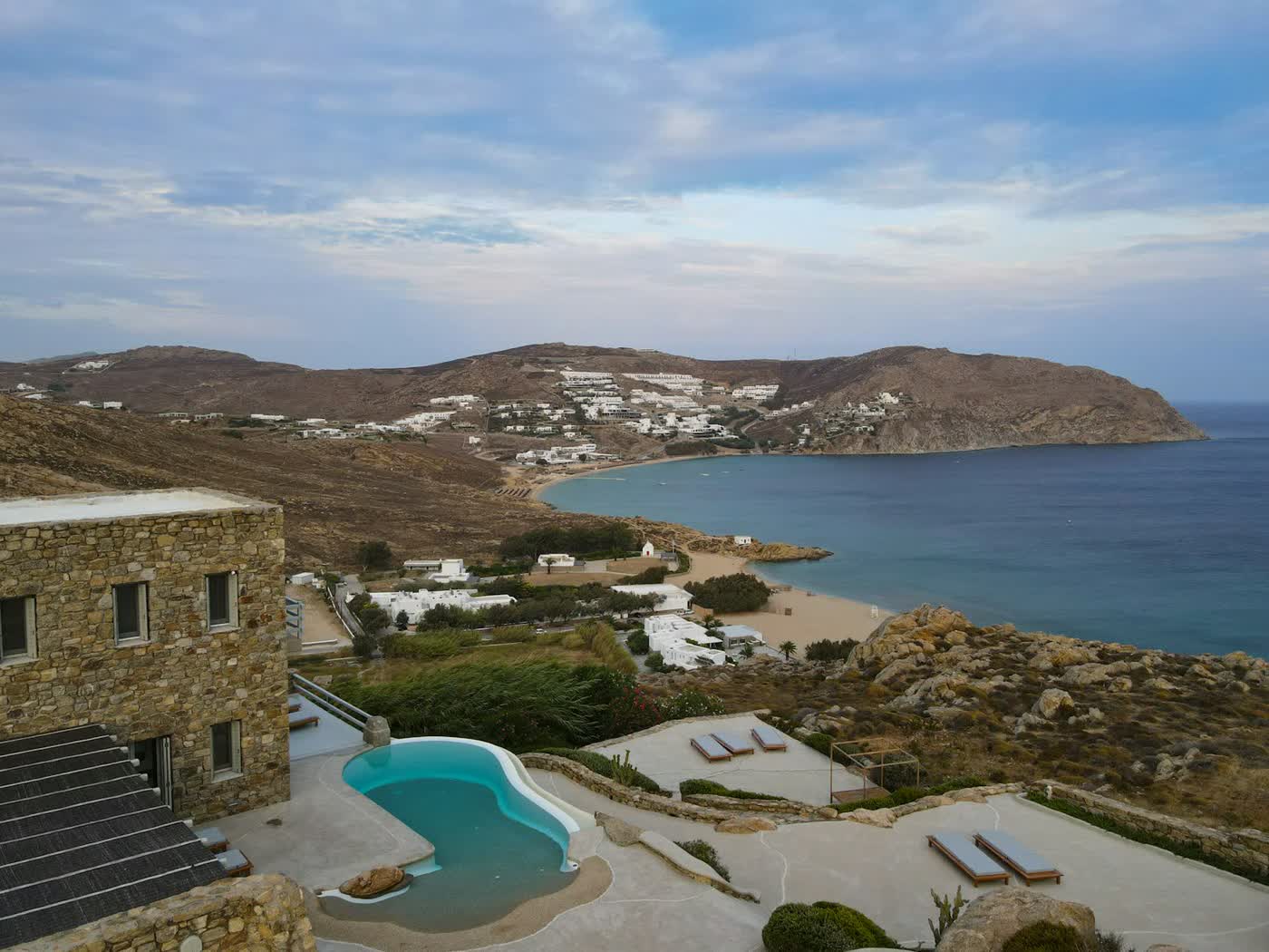 A stone house with a pool above a bay