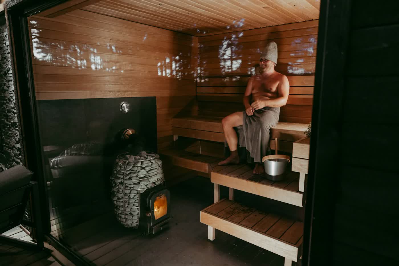 Inside a wooden sauna with the stove glowing